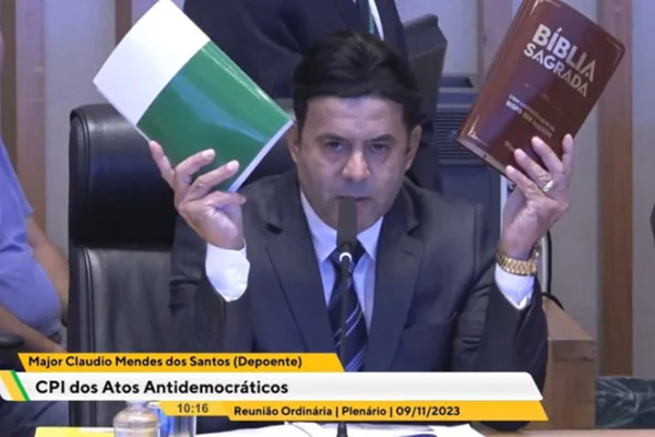Foto colorida de major segurando bíblia e constituição em CPI