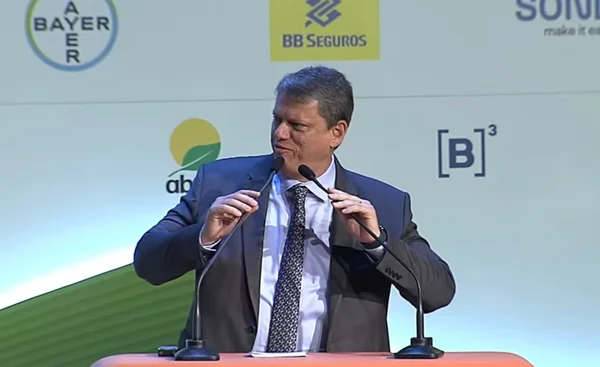 Imagem colorida de Tarcísio de Freitas, governador de São Paulo, falando em um microfone durante evento do agronegócio. Ele veste um terno escuro e usa gravata - Metrópoles