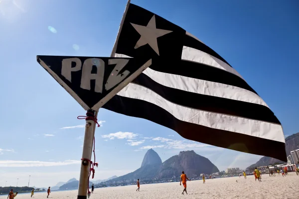 Bandeira do Botafogo na praia escrito paz - Metrópoles