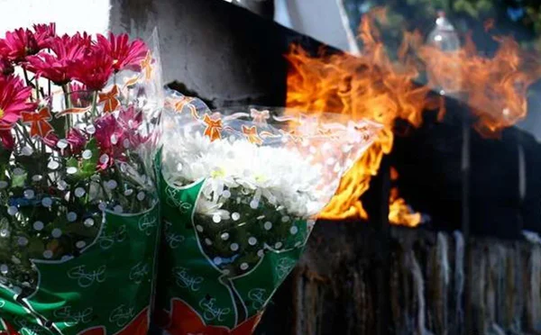 foto de flores em cemitério com chamas atrás