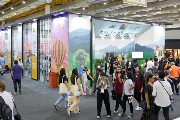 Imagem colorida mostra pessoas caminhando em pavilhão da Bienal do Livro de SP