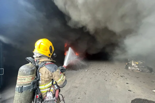 Imagem colorida de bombeiro apagando incêndio em Betim, MG