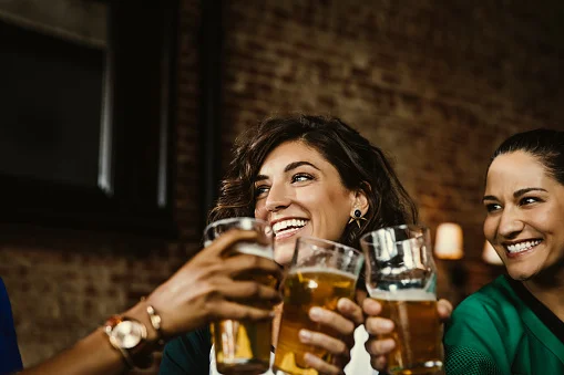 Amigos segurando copos de cerveja enquanto brindam