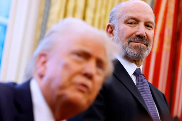 Imagem de Howard Lutnick, secretário de Comércio dos Estados Unidos, observando o presidente dos EUA Donald Trump - Metrópoles