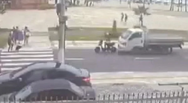 Imagem de caminhão se aproximando de jovem de bicicleta; pessoas atravessa, na faixa de pedestres - Metrópoles