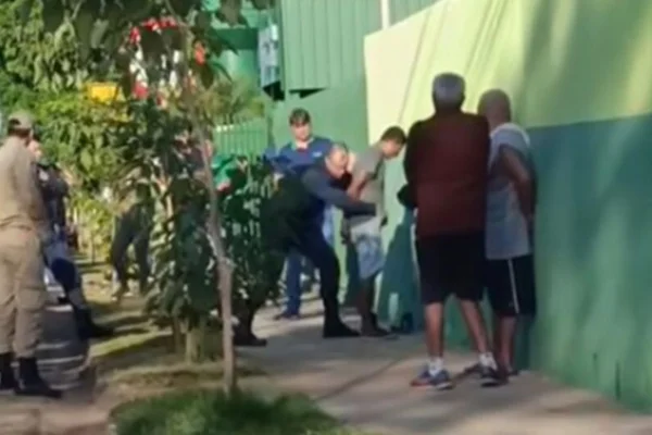 Imagem colorida, homem com faca domina e arrasta crianças em porta de escola- Metrópoles
