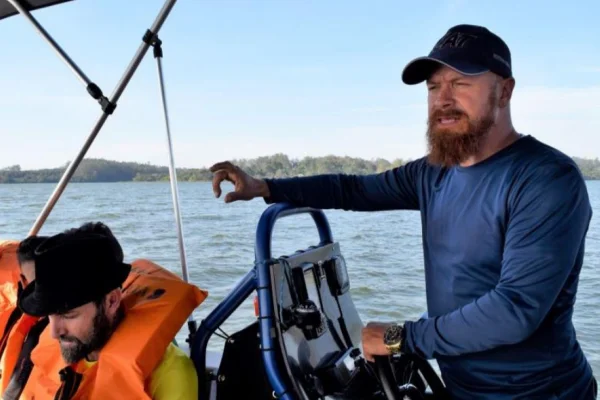 Imagem colorida de um homem no manete de um barco
