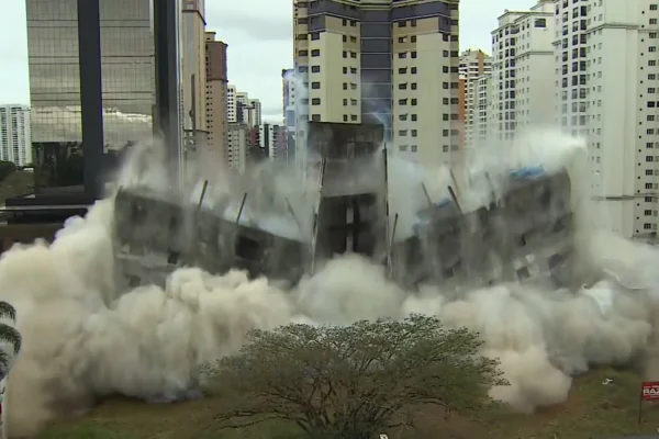 Imagem colorida de prédio sendo demolido