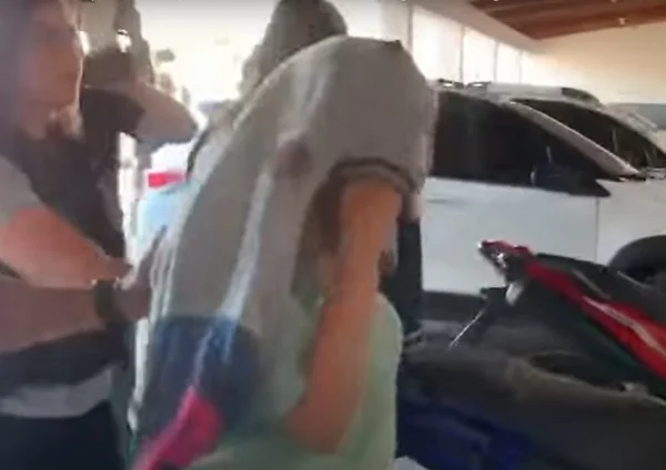 Foto colorida de Inês Gemilaki, que chegou à delegacia com o rosto coberto