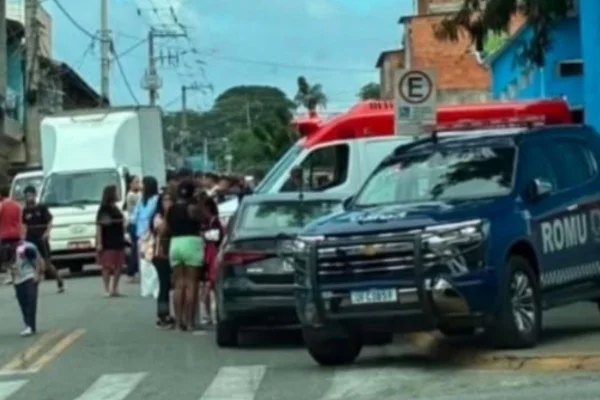 Imagem colorida mostra viaturas policiais em frente à escola onde professora foi esfaqueada.