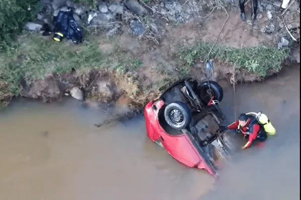 Imagem colorida de bombeiros tirando carro submerso da água - Metrópoles