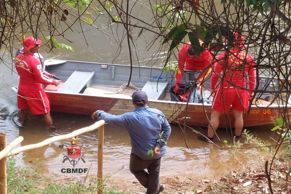 homens com roupas vermelha mexendo em equipamento em barco