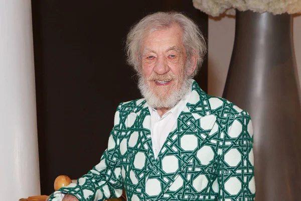 Na imagem colorida, ator Ian McKellen sorri e usa roupa verde estampada. Ator está de barba e cabelo brancos - Metrópoles