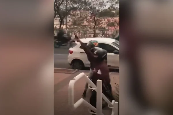 Imagem colorida mostra assaltante com arma apontada para o alto após golpe em venda de celular. Metrópoles