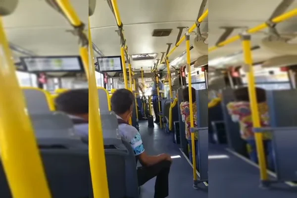 Passageiro de ônibus sentado, homem segura capacete de moto