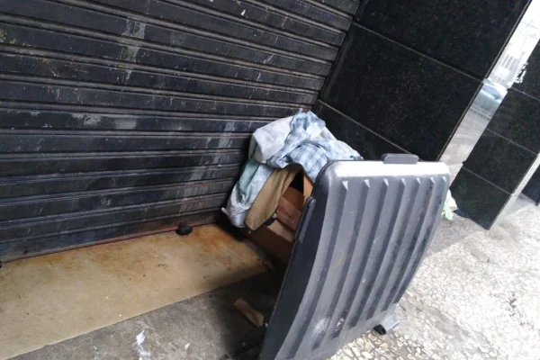 Foto colorida de calçada, papelão, tampa de lixeira e objetos de local onde moradora de rua foi estuprada em Santos - Metrópoles