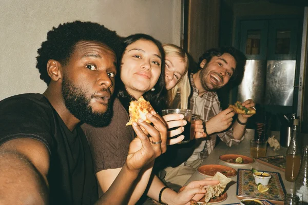 Grupo de jovens comendo em um restaurante - Metrópoles
