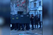 Nos vídeos, um dos agentes aparece apontando uma arma para os manifestantes