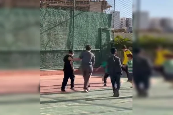 Meninos jogando futebol em quadra poliesportiva