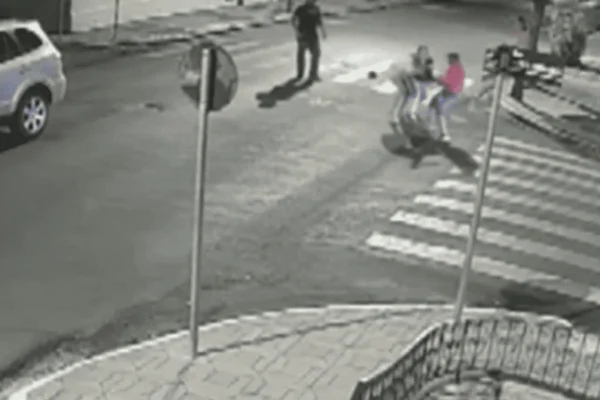 Imagem em preto e branco de um homem agredindo uma mulher grávida no meio da rua - Metrópoles