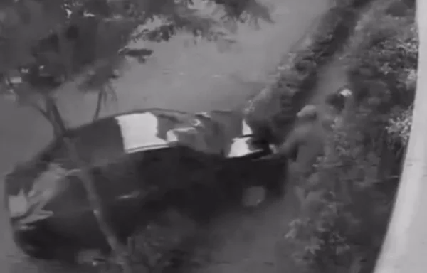 Imagem preta e branca de carro invadindo calçada, em direção a pessoas - Metrópoles