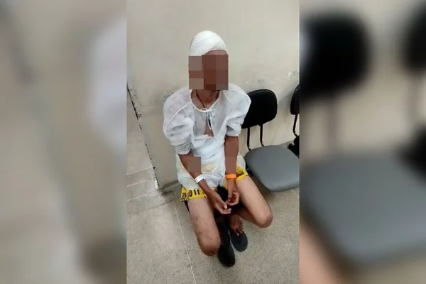 Imagem colorida de um homem sentado em uma cadeira com a cabeça enfaixada - Metrópoles