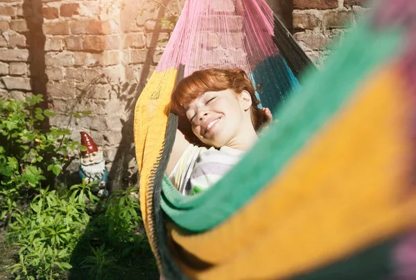 Foto colorida de mulher em descanso deitada em uma rede - Metrópoles
