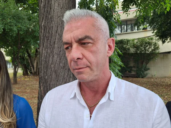 Imagem colorida mostra Alexandre Correa, ex-marido de Ana Hickmann, um homem branco de cabelos curtos grisalhos e camisa branca, chegando no Deic, em São Paulo - Metrópoles