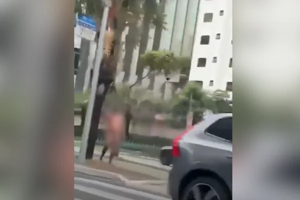 Imagem colorida de homem andando pelado pela Avenida Faria Lima. Metrópoles
