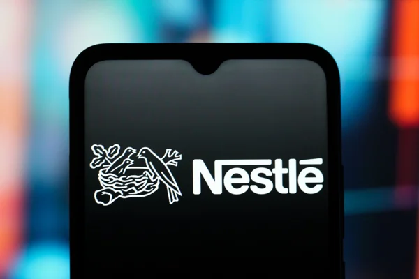 Imagem de celular exibindo imagem do logotipo da Nestlé, gigante multinacional suíça do setor de alimentos e bebidas - Metrópoles