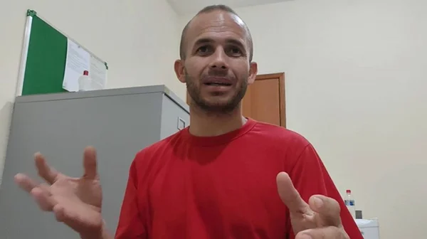 Imagem colorida de um homem utilizando camiseta vermelha- Metrópoles