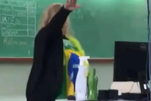 Professora faz gesto nazista em escola do Paraná. Ela é branca, loira e usa camisa com estampa da bandeira do Brasil - Metrópoles