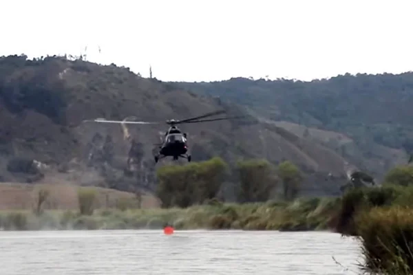 Helicóptero sobrevoando área costeira, acima da água - Metrópoles
