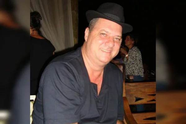 Homem branco com camisa e chapéu pretos - Metrópoles