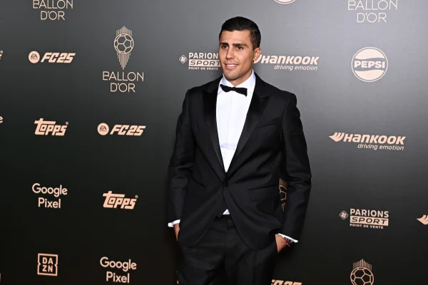 Foto colorida de Rodri, de terno preto, em cerimônia da Bola de Ouro - Metrópoles