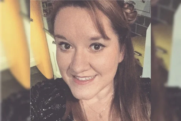 Imagem colorida de mulher vestida de preto enquanto sorri para selfie - Metrópoles