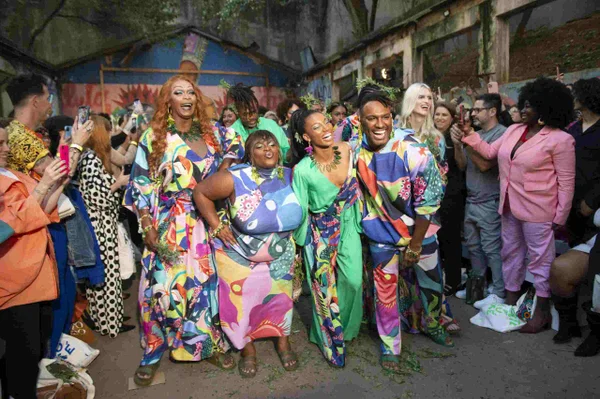 Marcia Pantera, Jojo Todynho, Fred Nicácio e Tina Calamba usando looks coloridos, em meio a grupo de pessoas, no desfile da marca Isaac Silva - Metrópoles