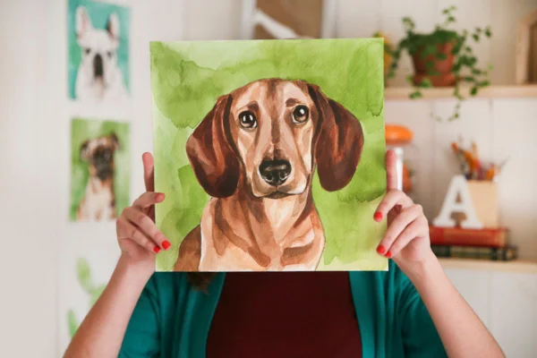 Imagem colorida de mulher segurando pintura de cachorro