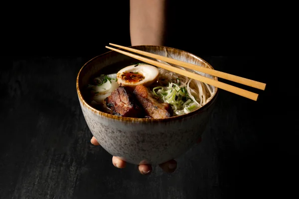 Imagem mostra tigela de lamen, um tipo de macarrão japonês com caldo, ovo e pedaços de carne, e dois hashis - Metrópoles