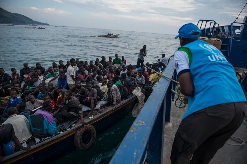 Um membro do ACNUR puxa um barco carregando refugiados do Burundi para outro barco que irá transportá-los através do Lago Tanganyika para a cidade de Kigoma, na Tanzania e até o acampamento Nyarugusu. Desde que os problemas políticos no país se tornaram violentos em 2015, mais de 400 mil burundianos migraram através da Tanzania, Ruanda, Uganda e a República Democrática do Congo. A falta de fundos monetários para a situação de refugiados burundianos impediram os esforços dos comitês de recepção e diminuíram o espaço para asilo dos refugiados. Além disso, também diminuiu a qualidade da proteção pelos países hospedeiros. A ACNUR continua relocando aqueles que ainda atravessam as fronteiras fugindo da perseguição de milícias pró-governo. A congestão em acampamentos, falta de materiais disponíveis para abrigo, falta de comida, água e provisões de saúde e serviços de educação foram afetados. Enquanto o ACNUR busca fazer o necessário, ele também busca ajuda monetária da comunidade internacional e de indivíduos para ajudar em uma das crises de refugiados menos financiadas do mundo Um membro do ACNUR puxa um barco carregando refugiados do Burundi para outro barco que irá transportá-los através do Lago Tanganyika para a cidade de Kigoma, na Tanzania e até o acampamento Nyarugusu. Desde que os problemas políticos no país se tornaram violentos em 2015, mais de 400 mil burundianos migraram através da Tanzania, Ruanda, Uganda e a República Democrática do Congo. A falta de fundos monetários para a situação de refugiados burundianos impediram os esforços dos comitês de recepção e diminuíram o espaço para asilo dos refugiados. Além disso, também diminuiu a qualidade da proteção pelos países hospedeiros. A ACNUR continua relocando aqueles que ainda atravessam as fronteiras fugindo da perseguição de milícias pró-governo. A congestão em acampamentos, falta de materiais disponíveis para abrigo, falta de comida, água e provisões de saúde e serviços de educação foram afetados. Enquanto o ACNUR busca fazer o necessário, ele também busca ajuda monetária da comunidade internacional e de indivíduos para ajudar em uma das crises de refugiados menos financiadas do mundo