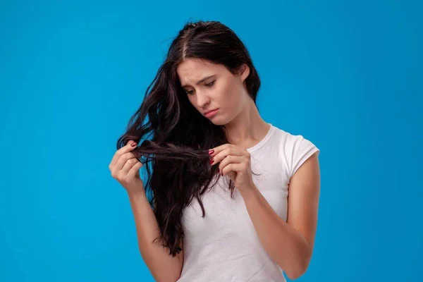 Foto colorida - mulher olhando o cabelo