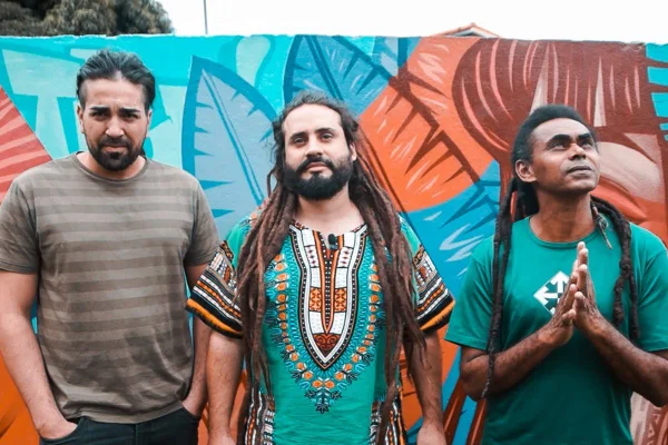 três homens posam um ao lado do outro