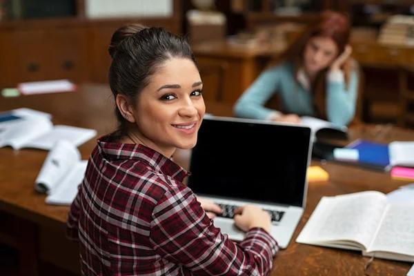 estudante com blusa xadrez usando um notebool