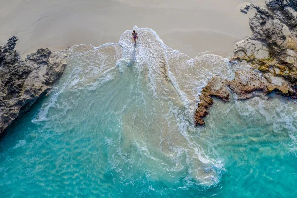 pessoa andando numa praia nas Bahamas