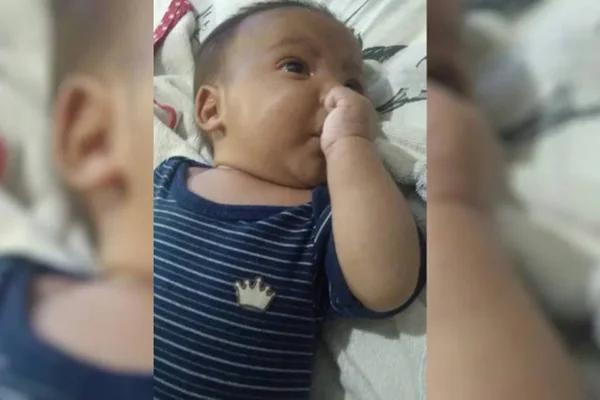bebÊ com body azul chupando dedo