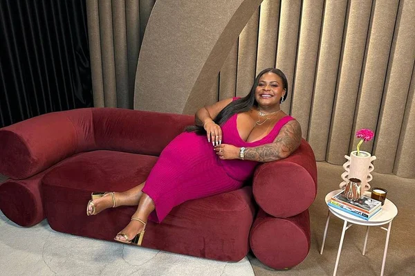 Fofo colorida de Jojo Todynho sentada em uma poltrona com vestido rosa e de pernas cruzadas
