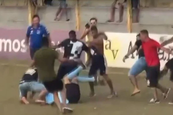 Imagem colorida mostra grupo de torcedores batendo em árbitro durante partida de futebol amador em Tambaú, no interior de São Paulo - Metrópoles