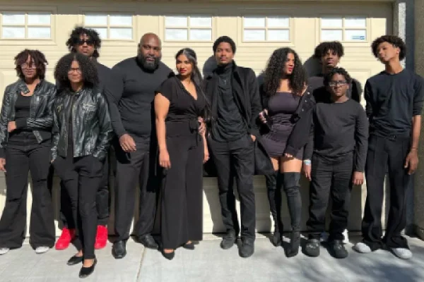 Foto colorida de homens e mulheres vestidos de preto