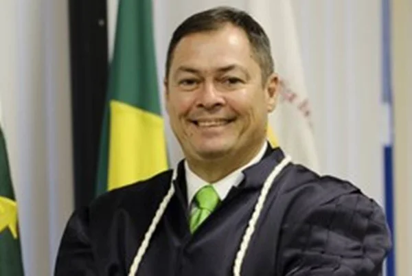 Desembargador Carlos Pires Soares Neto, que tomara posso no TJDFT nesta sexta-feira (8/7). Ele sorri olhando para a câmera, frente a bandeira do Brasil - Metrópoles