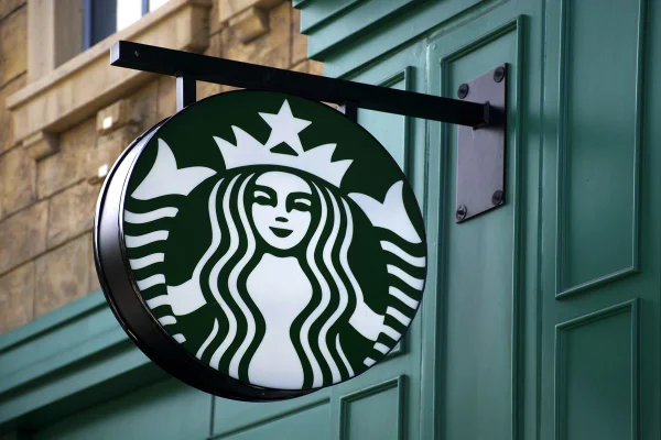 Imagem de logotipo da Starbucks na entrada de uma loja da companhia, nas tradicionais cores verde e branca - Metrópoles